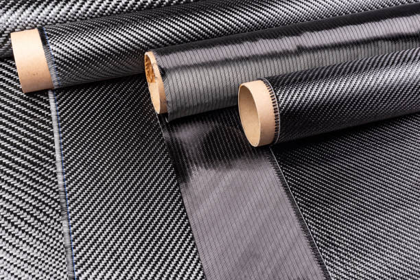 Rolls with various real woven carbon fiber enforcement raw material cloth. composite material automotive and car tuning industry and high tech background.